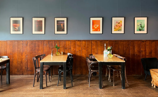 Wide view of the ooohhh.art exhibition at Café Fabriek in Zaandam, with framed artworks installed throughout the interior.